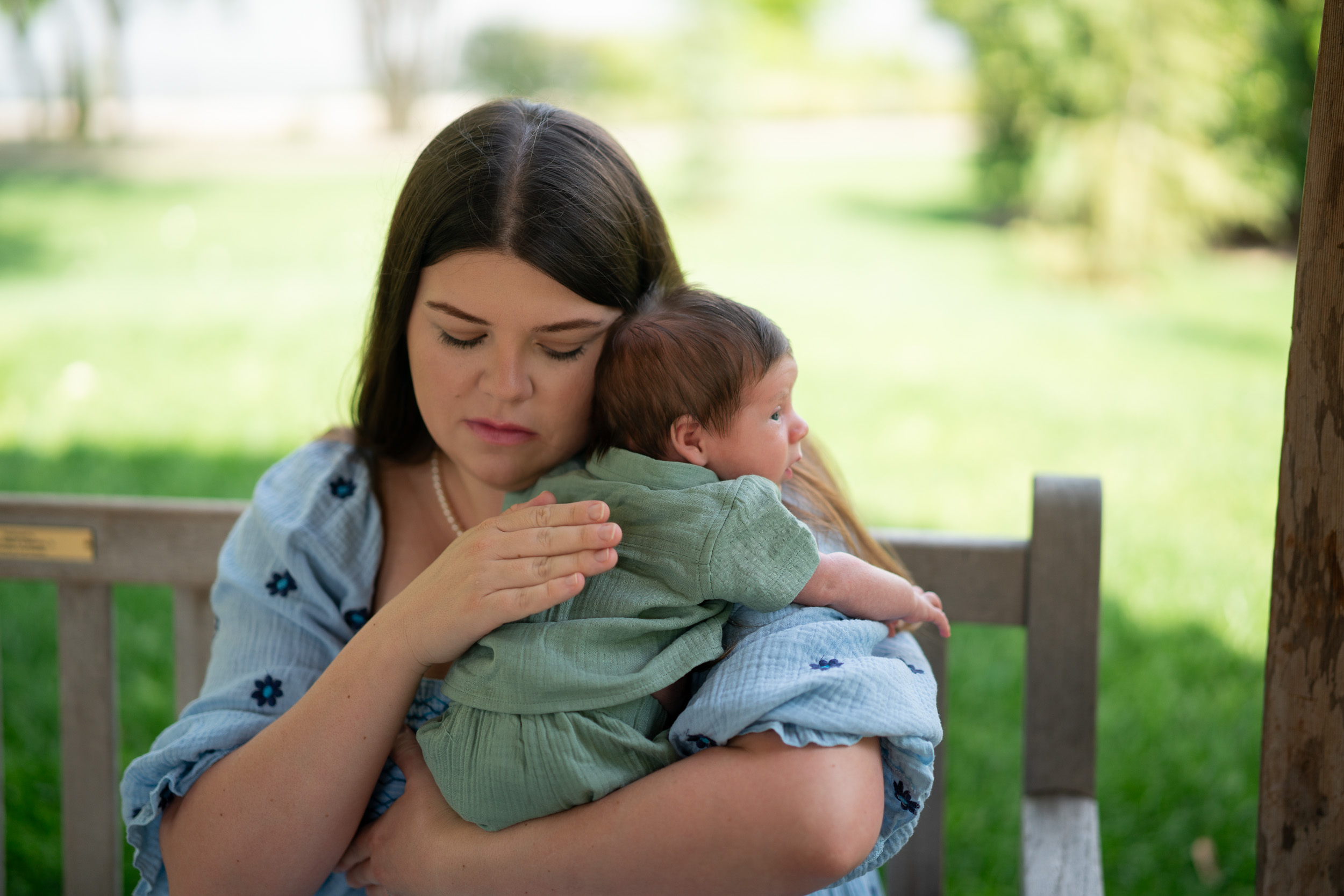 Mother with her newborn on a park bench